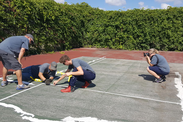 Skye Whitcomb captures high school students repairing tennis courts at their high school during her UM-Flint Communication internship