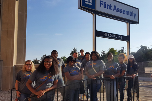 Skye Whitcomb (far left) stands with her Flint Southwestern high school students outside GM’S Flint Assembly Plant.