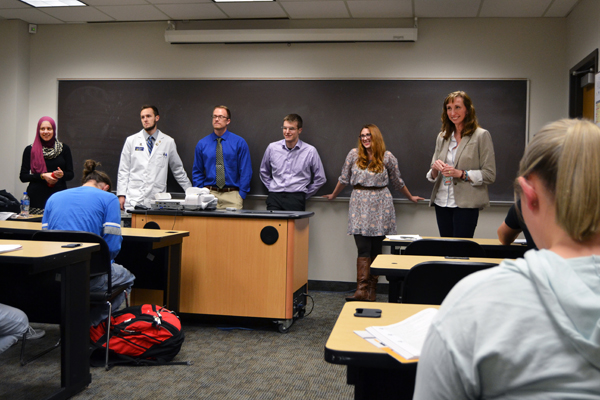 Jessica Tischler, PhD, Chair of UM-Flint's Chemistry and Biochemistry Department (standing, far right), introduces her former students. 
