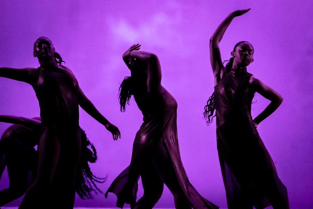 Dancers in silhouette against a purple backgound