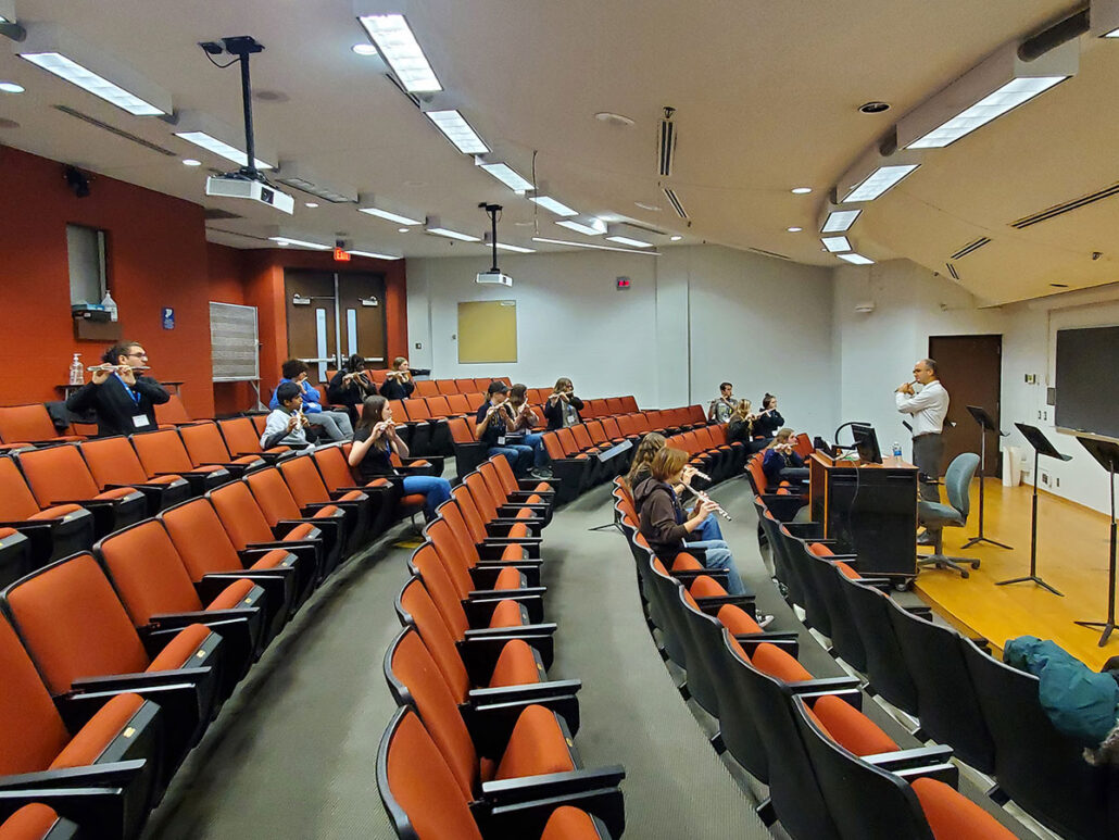 UM-Flint music instructor teaching high school flute students in an auditorium