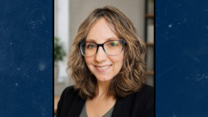 Portrait of Amanda Smith, Lecturer IV in Psychology and Psychology Club Advisor, with shoulder-length wavy hair, wearing a black blazer and green top.
