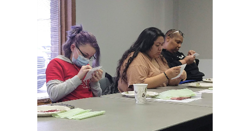 One um-flint student and two students of the Saginaw-Chippewa Tribal College work on a traditional Ojibwe beading project.